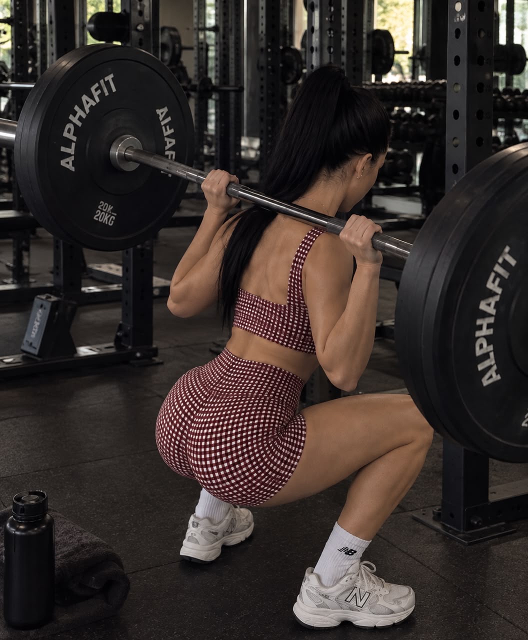 Woman performing a barbell squat in the gym